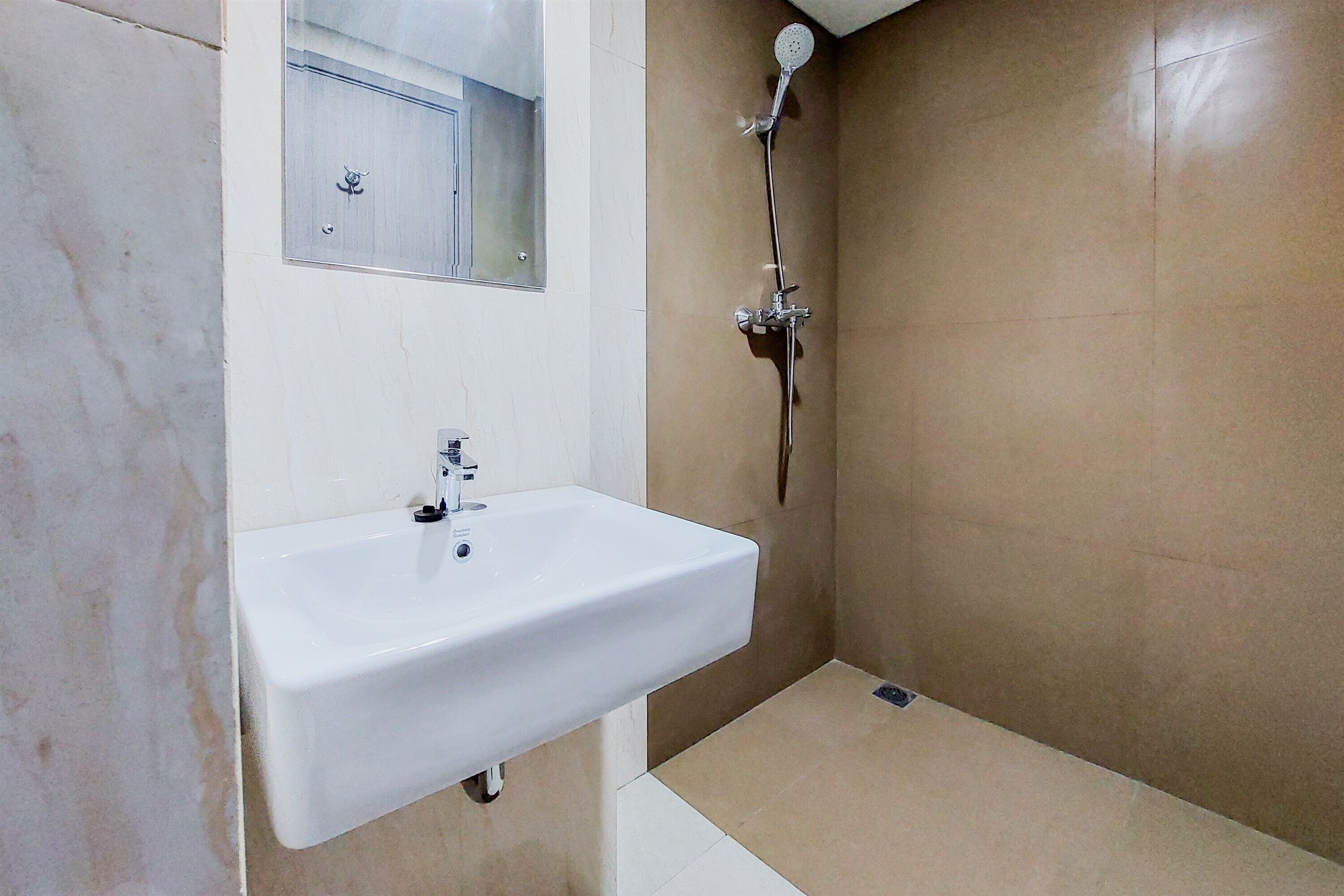 A bathroom with a white sink, a mirror, and a shower.
