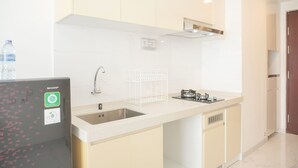 Een moderne keuken met witte kastjes, een roestvrijstalen spoelbak en een ingebouwde gasfornuis.