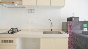 Una cuina moderna amb una campana extractora d'acer inoxidable, un vàter encastrat i un frigorífic amb dispensador d'aigua.