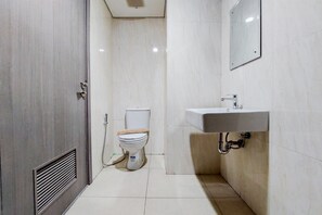 A small, modern bathroom with a toilet, sink, and ventilation. - Simply Look And Comfort 1Br Tamansari Bintaro Mansion Apartment (South Tangerang)