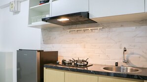 A modern kitchen with a stainless steel sink, a gas stove, and a built-in oven. - Best Deal And Well Furnished 2Br Bassura City Apartment (Jakarta)