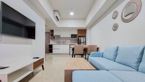 A modern living room with a flat-screen TV, a light blue sofa, and a wooden coffee table.