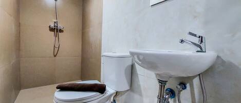 A bathroom with a toilet, a sink, and a shower.