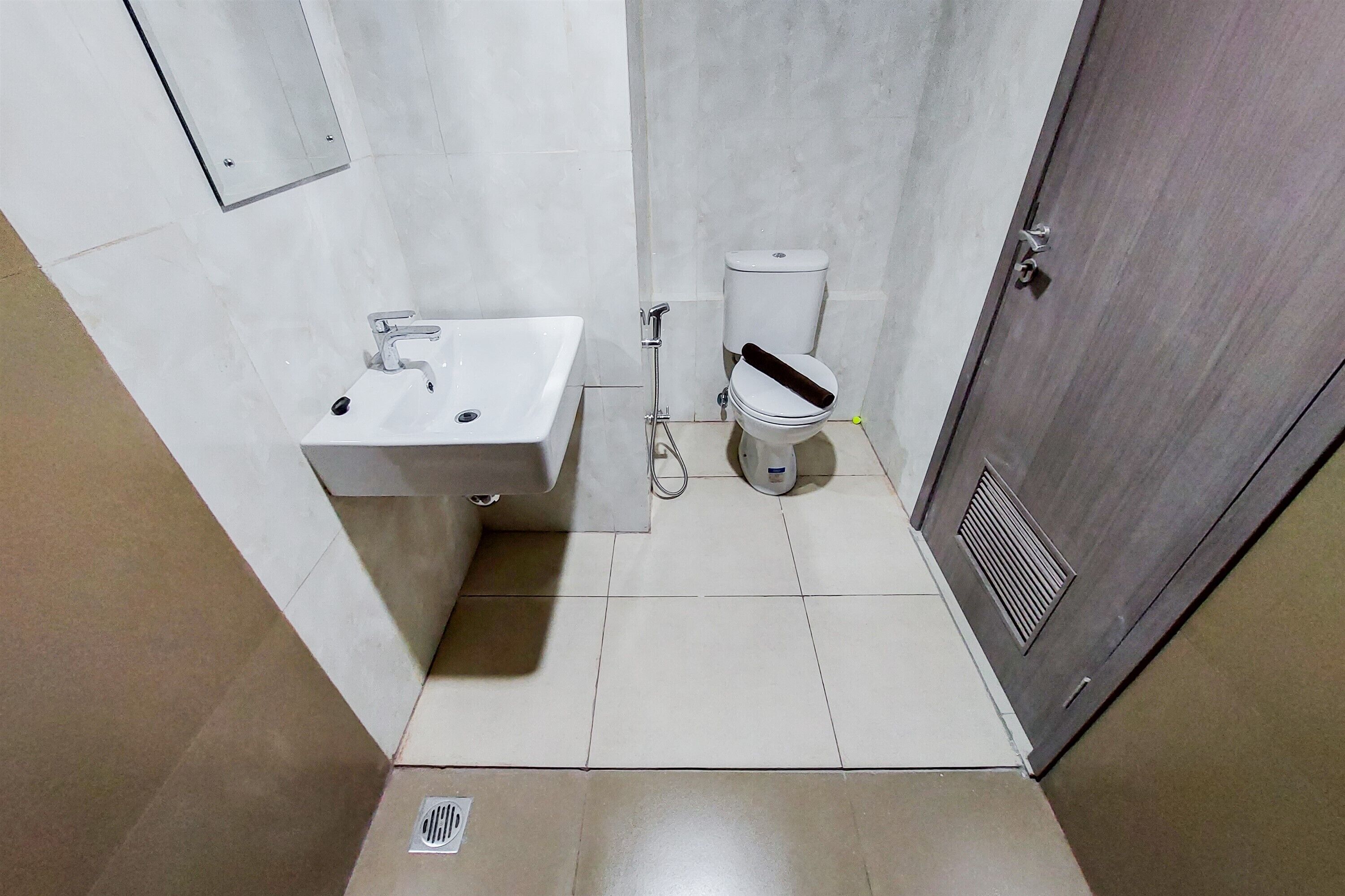 A small, clean bathroom with a white sink, toilet, and shower.