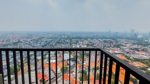 A cityscape viewed from a balcony with a railing. - Nice And Homey 3Br Tamansari Bintaro Masion Apartment (South Tangerang)