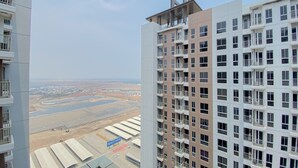 Un immeuble de grande hauteur doté de nombreux balcons et offrant une vue sur un paysage lointain.