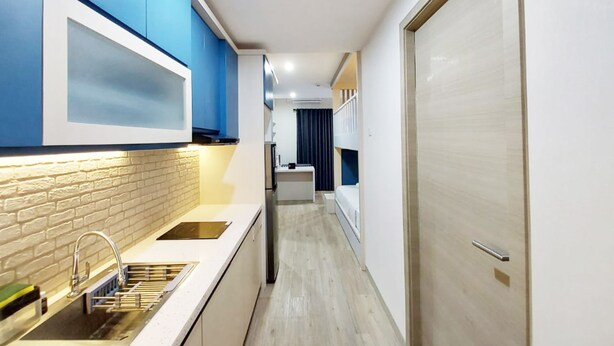 A narrow hallway with a kitchen area on the left, featuring a sink and cabinets. - Cozy Stay Studio At Mataram City Apartment (Ngaglik)