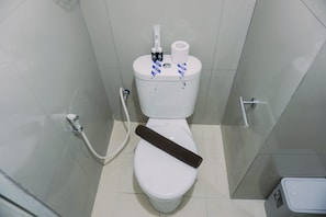 Des toilettes équipées d’un porte-rouleau de papier toilette, d’un jet bidet et d’un abattant-bidet.
