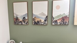 A bedroom with a bed, a bedside table with a clock, and three framed artworks on the wall. - Between Crystal Mountain & TC - Barn - Guest house on 10acres. Pet-friendly! (Interlochen)