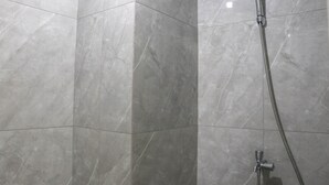 A shower area with a handheld showerhead and a flexible hose. - Cozy And Comfort Stay Studio Sayana Bekasi Apartment (Tarumajaya)