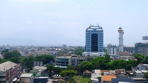 Un paisaje urbano con un edificio moderno destacado, una mezquita y zonas residenciales circundantes.