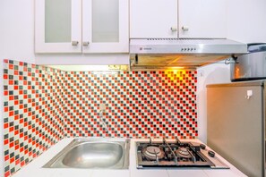 Studio | Privékeuken | Een koelkast met diepvriezer, een kookplaat