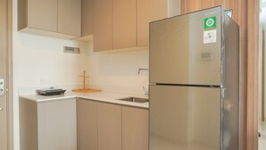 A modern kitchen with a stainless steel refrigerator, a built-in oven, and a microwave. - Wonderful And Homey 2Br At Gold Coast Apartment (Jakarta)