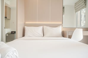 Ett modernt hotellrum med en stor säng, ett skrivbord och en stol.
