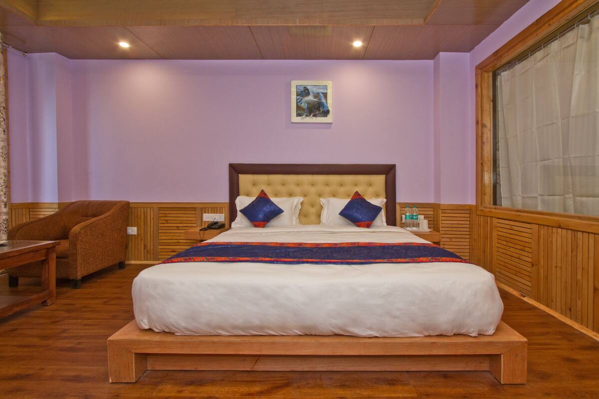 A bedroom with a large bed, wooden headboard, and a wooden bench.