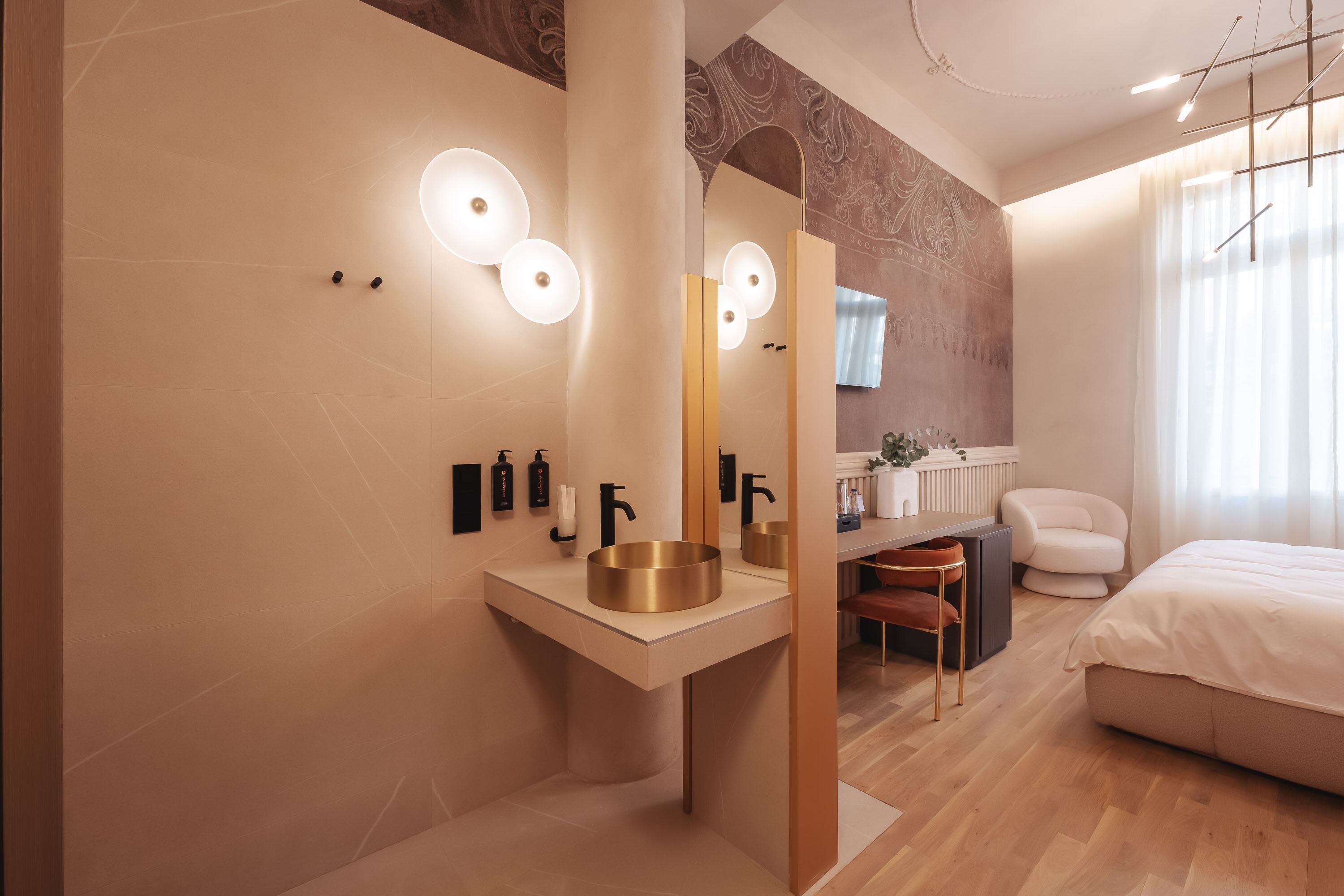 A modern bathroom with a large mirror, a gold sink, and a white vanity.