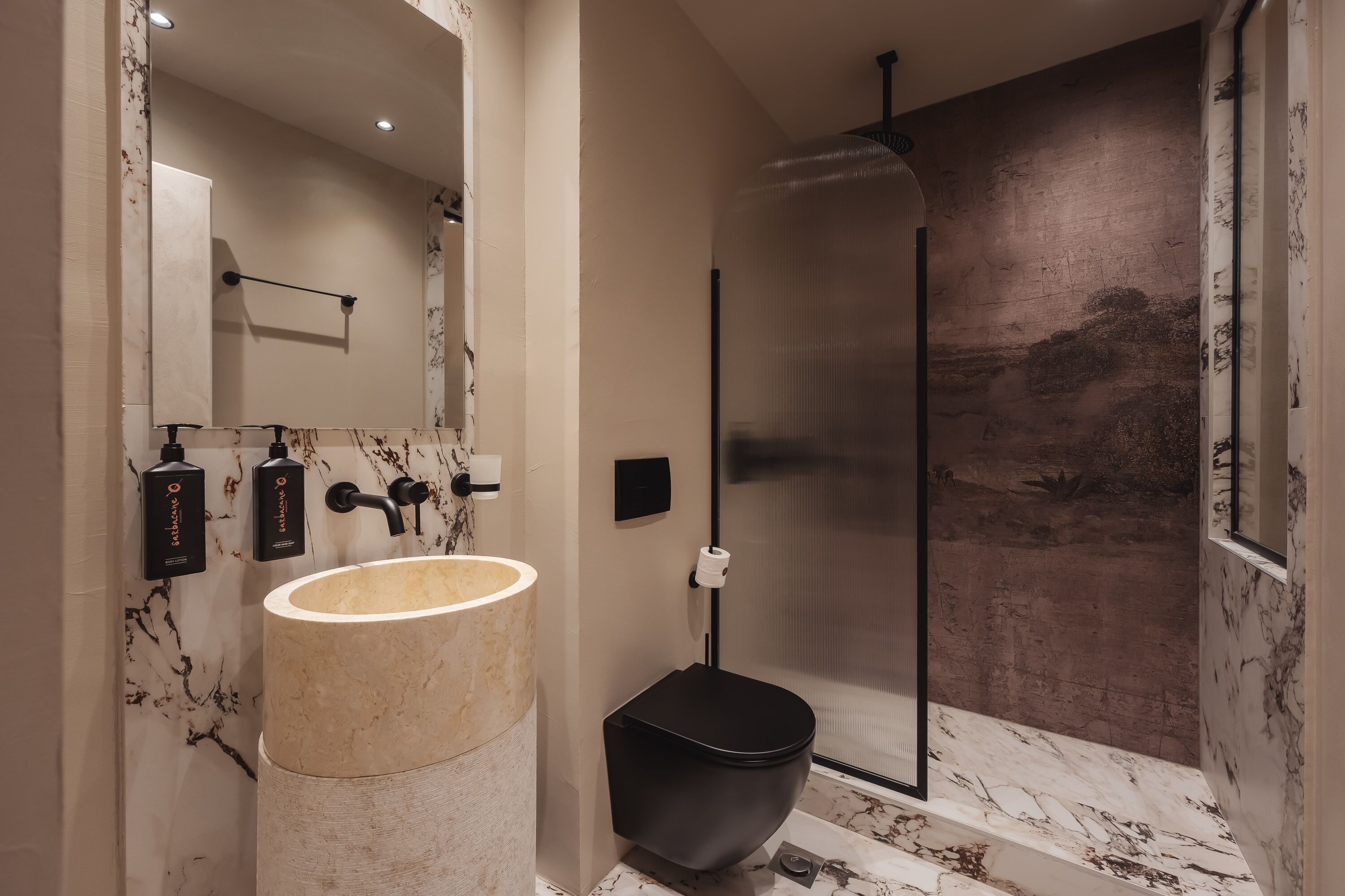Ein modernes Badezimmer mit Marmorwaschbecken, Toilette in Schwarz und einer Duschkabine aus Glas.