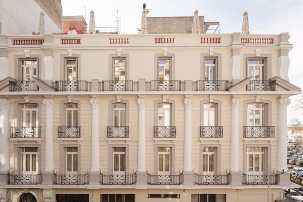 A multi-story building with a classical architectural style, featuring symmetrical windows, ornate balconies, and a central entrance. - Zenith Premium Suites (Thessaloniki)