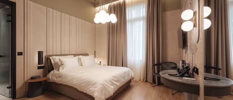 A modern bedroom with a large bed, bedside tables, a round mirror, and a built-in vanity with lighting.