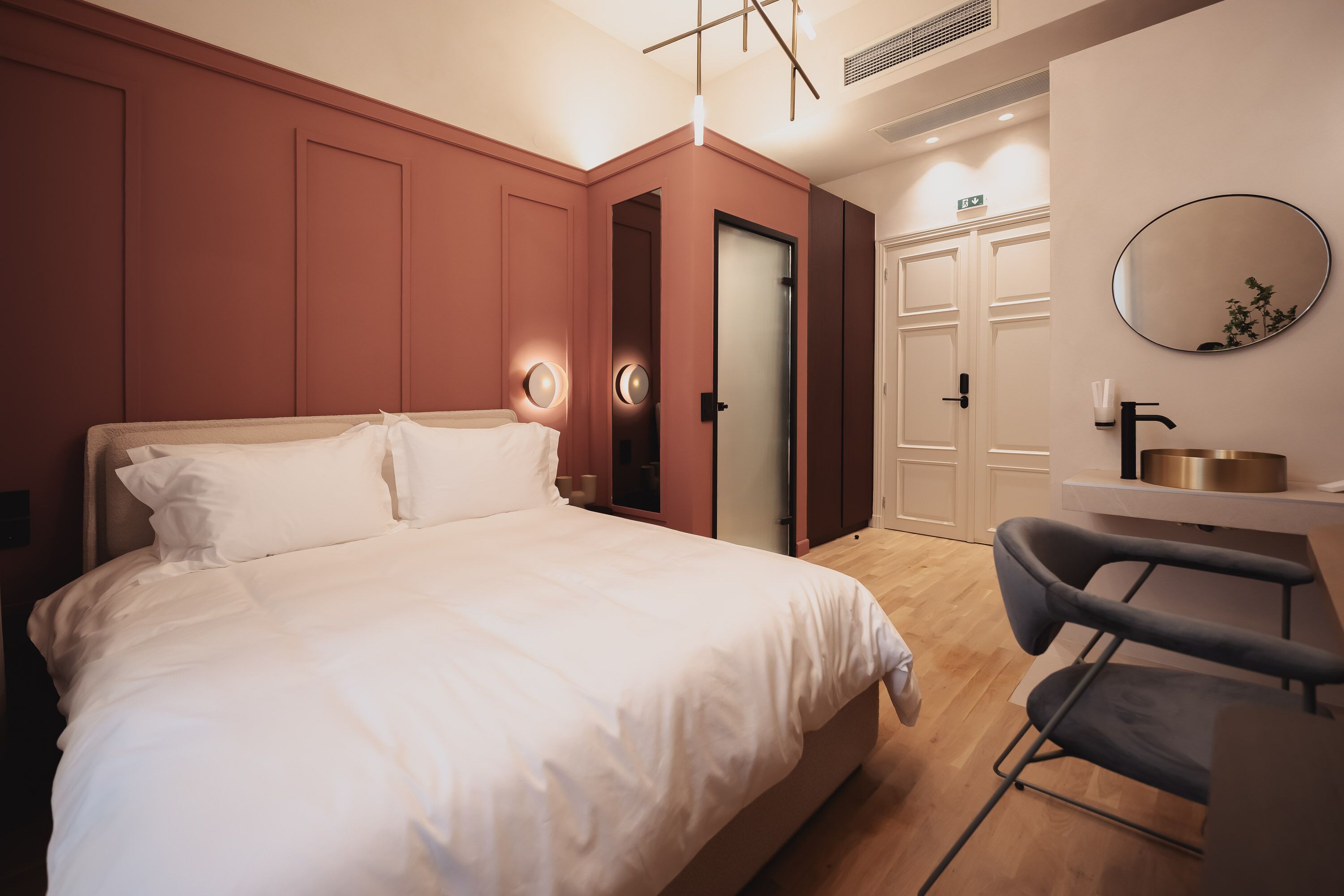 Un dormitorio moderno con una cama grande, un escritorio y un espejo.