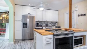 A modern kitchen with a built-in oven, microwave, and stainless steel refrigerator. - Little Venice Family Affair 2 bedroom 1 bath One Block from the Ocean (Marathon)