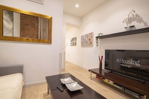 Ein modernes Wohnzimmer mit Flachbildfernseher, Couchtisch, Sofa und Kamin.