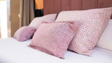 Una cama con almohadas estampadas y cabecera de madera.