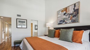 Ein Hotelzimmer mit einem großen Bett, einer Nachttischlampe und einem Bild an der Wand.