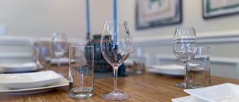 A dining table with various glassware and plates, set for a meal.