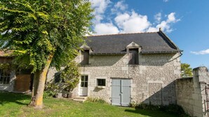 A stone house with a grey door, a small window, and a chimney. - Vacances Gites Assay Maisons Chaleureuse (Assay)