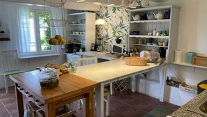 A kitchen with white cabinetry, a wooden table, and various kitchen appliances. - Comfortable holiday home in the countryside, pool (Rozewko)