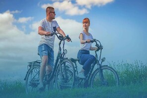 Two people riding bicycles in a grassy field with a clear sky. - Comfortable holiday home in the countryside, pool (Rozewko)