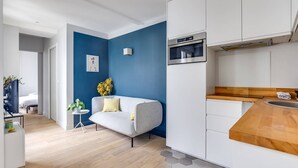 Une cuisine moderne avec des armoires blanches, un four encastré et un plan de travail en bois.