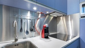 A modern kitchen with stainless steel appliances, a built-in sink, and a utensil rack.