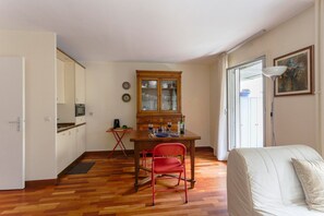 A compact living space with a kitchenette, dining area, and a bed. - GuestReady - studio at parc des Buttes-Chaumont (Paris)