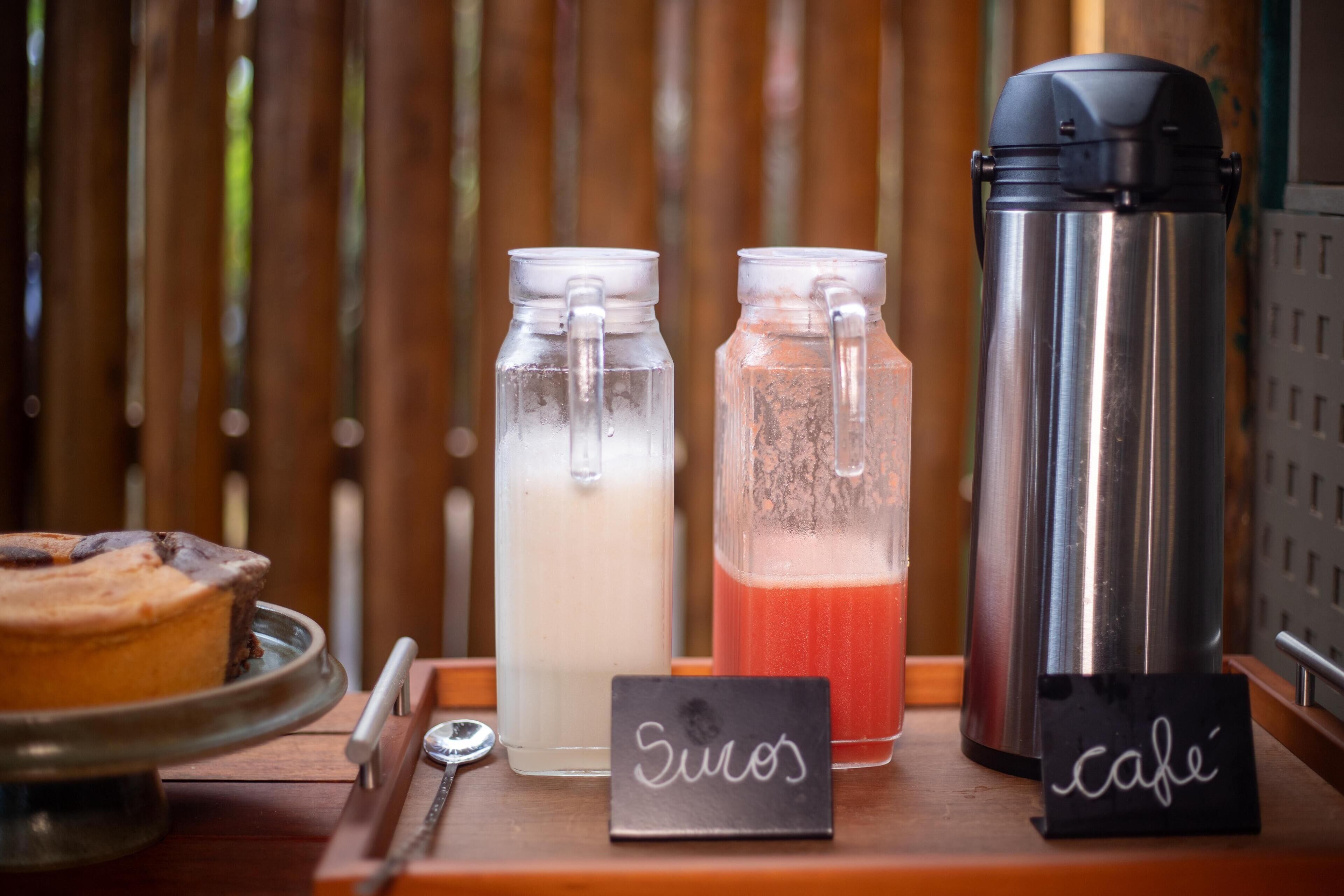 A beverage station with three drink dispensers, a sign labeled 'Suos', and a sign labeled 'cafe'.