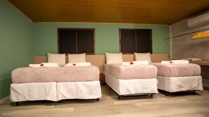 A room with two beds, each with a white quilted bedspread and pillows, and a wooden ceiling. - Bella Rosa Noronha (Fernando de Noronha)