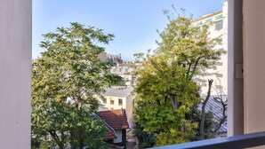 Blick aus einem Fenster auf eine Stadtlandschaft mit Gebäuden und Bäumen.