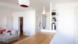 Eine moderne Küche mit weißen Schränken, einer Holz Arbeitsplatte und Pendelleuchten.