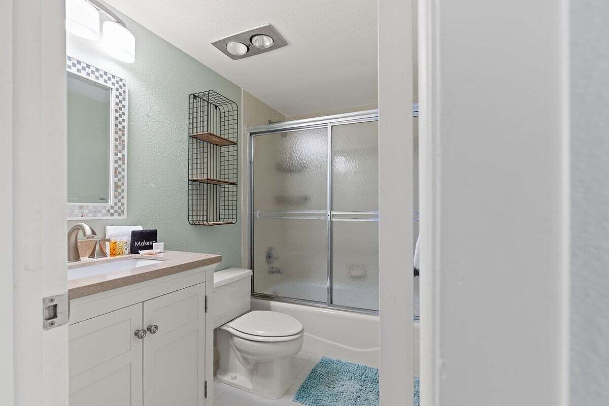 A bathroom with a toilet, sink, and shower.