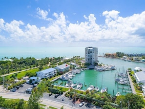 A marina with boats docked, a tall building with a red star, and a clear blue sky.