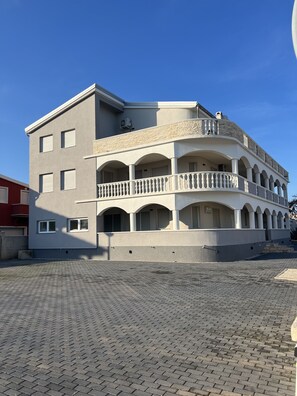 A multi-story building with a central courtyard, balconies, and a stone facade.