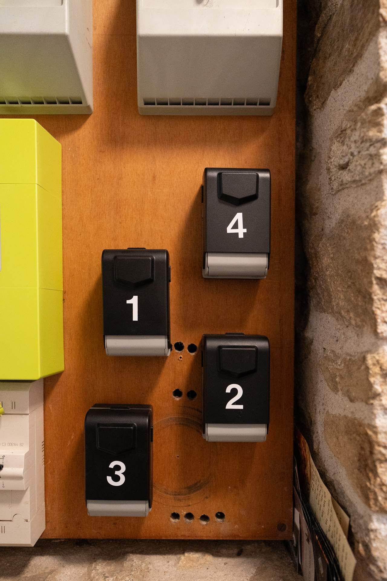 A wall-mounted control panel with four numbered buttons (1 to 4) and a yellow box to the left.