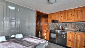 Eine Küche mit Holzausstattung, einer Arbeitsplatte aus Granit und einem eingebauten Backofen.