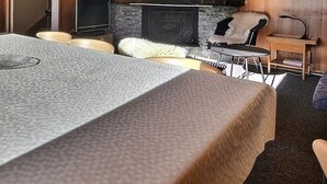Hyggelig opholdsstue med pejs, sofa og spisebord.