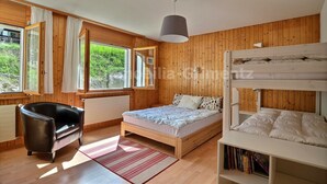 A room with wooden walls, a bunk bed, a sofa, and a window with curtains. - Very comfortable flat for 5 people, living room with fireplace, kitchen area with dishwasher, 1 2-be (Grimentz)