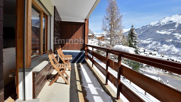 A balcony with wooden chairs and a view of snow-covered mountains. - Very comfortable flat for 7 people, living room with fireplace, kitchen area with dishwasher, 1 doub (Grimentz)