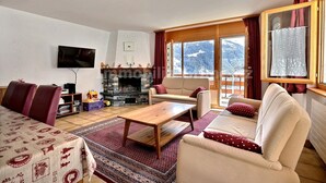 A living room with a sofa, armchairs, a coffee table, and a fireplace. - Very comfortable flat for 7 people, living room with fireplace, kitchen area with dishwasher, 1 doub (Grimentz)