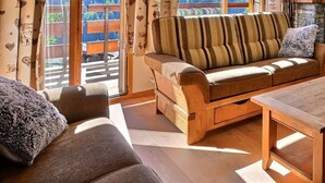 Un soggiorno accogliente con un divano in legno, un tavolino da caffè e un camino in pietra.