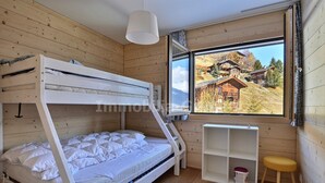 Camera con letto a castello e vista su un borgo montano.